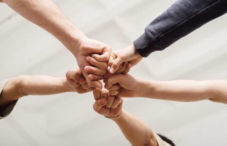 Manos unidas en símbolo de colaboración y trabajo en equipo.