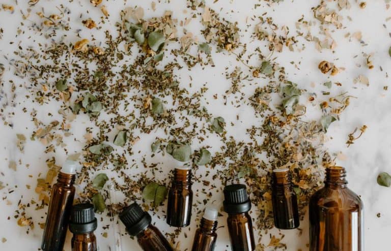 Aceites esenciales y hierbas para masajes en fondo blanco.