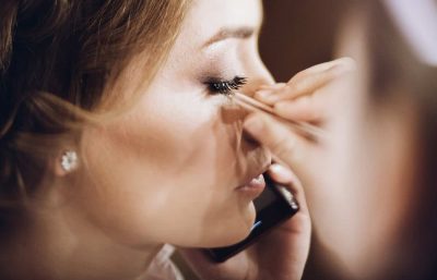 Mujer con maquillaje profesional y pestañas largas en sesión de belleza.